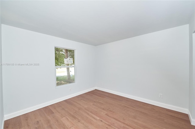 spare room featuring light wood-style flooring and baseboards