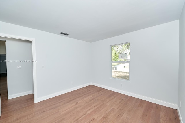 spare room featuring light wood-type flooring and baseboards
