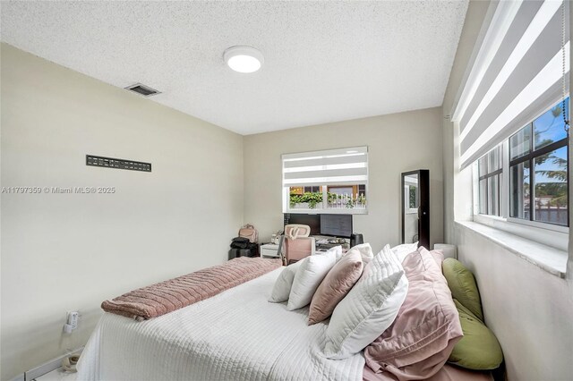 707 W 39th Pl, Hialeah, FL 33012 - bedroom with multiple windows and a textured ceiling