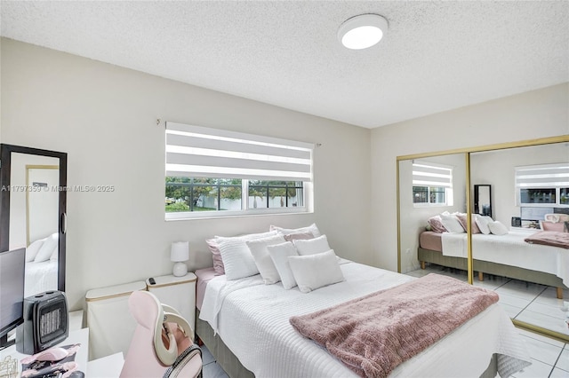 707 W 39th Pl, Hialeah, FL 33012 - tiled bedroom featuring multiple windows, a closet, and a textured ceiling