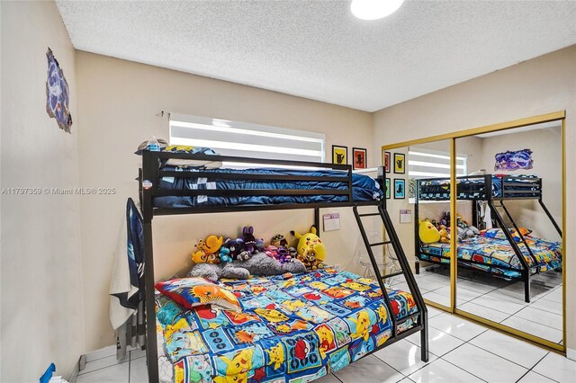707 W 39th Pl, Hialeah, FL 33012 - bedroom with a textured ceiling and tile patterned flooring