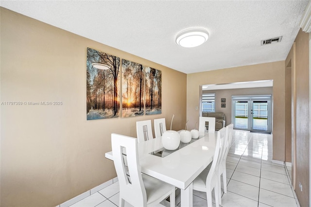 707 W 39th Pl, Hialeah, FL 33012 - dining area featuring light tile patterned flooring and a textured ceiling
