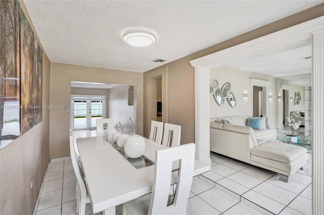 707 W 39th Pl, Hialeah, FL 33012 - dining space featuring light tile patterned flooring and a textured ceiling