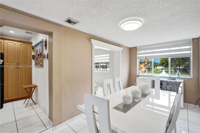 707 W 39th Pl, Hialeah, FL 33012 - dining room with light tile patterned flooring and a textured ceiling