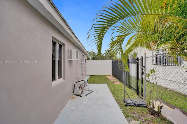 707 W 39th Pl, Hialeah, FL 33012 - fenced backyard with an AC wall unit and a patio area