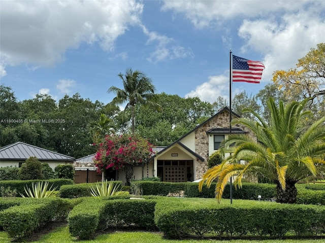view of front of property with stone siding and a standing seam roof