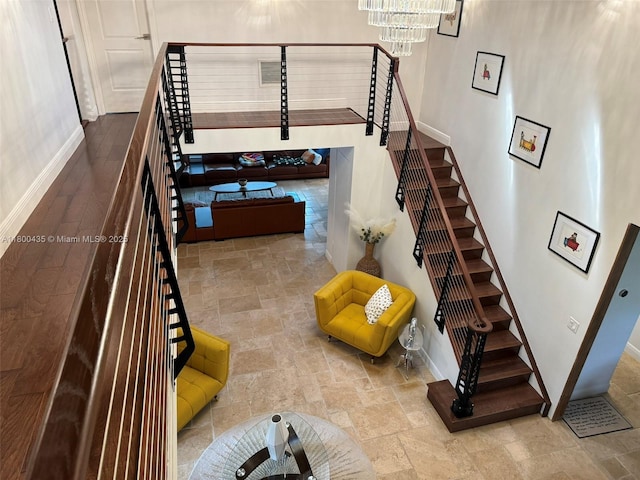 stairs with stone tile flooring, baseboards, and a chandelier