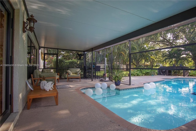 outdoor pool with a patio and glass enclosure