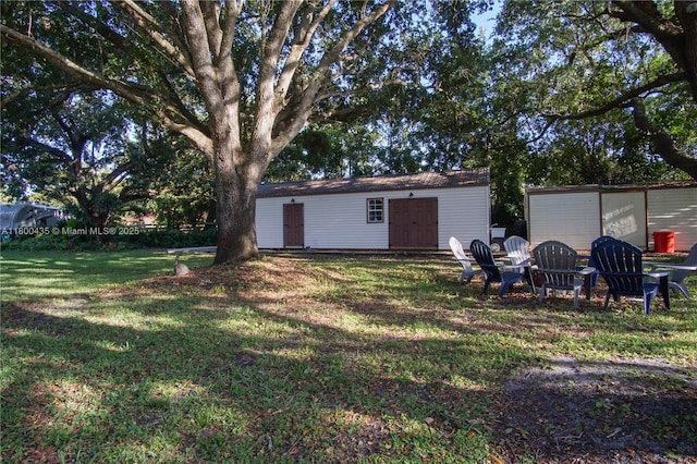 view of green lawn featuring an outbuilding