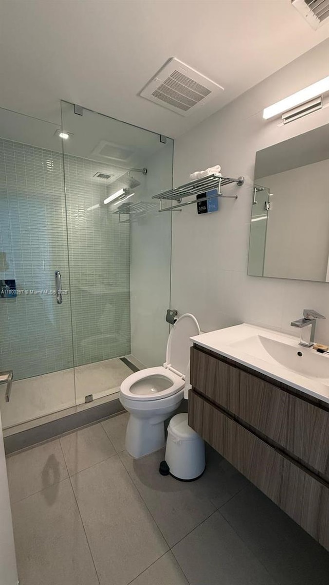 6080 Collins Ave Unit 402, Miami Beach, FL 33140 - bathroom featuring tile patterned flooring, toilet, a shower stall, and vanity
