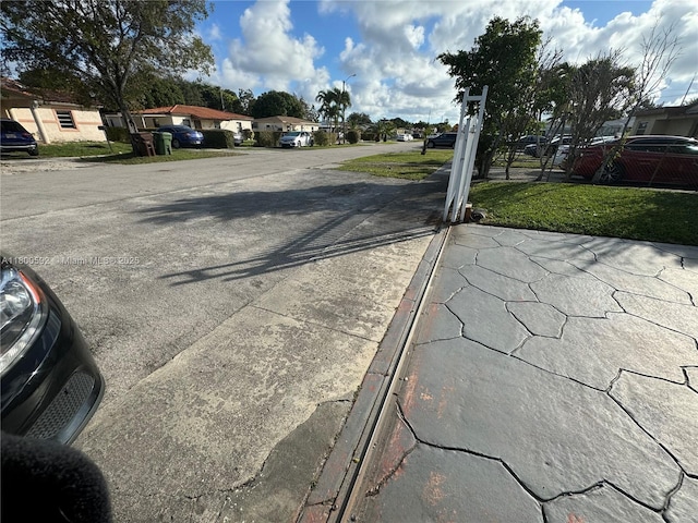 view of asphalt road with street lights and a residential view