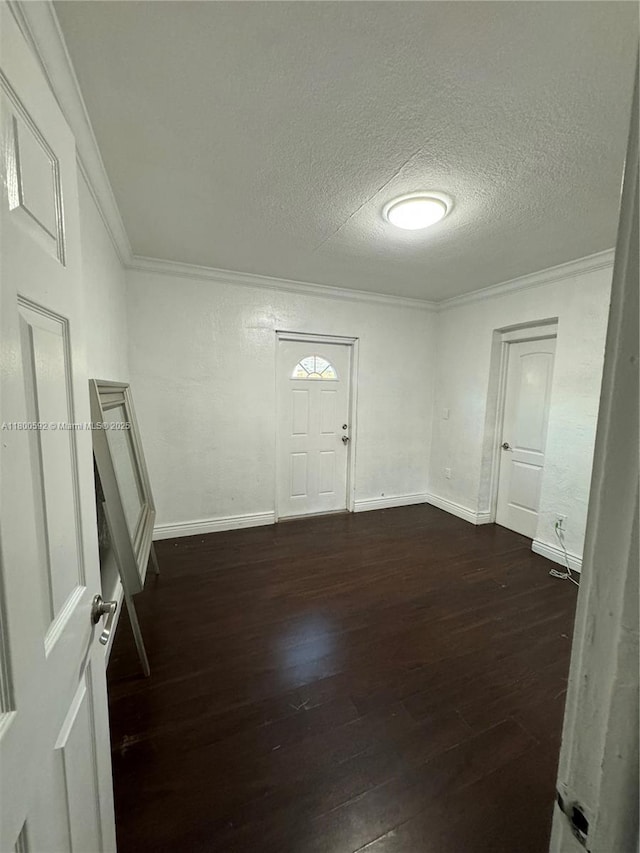 entrance foyer with ornamental molding, dark wood-style flooring, a textured ceiling, and baseboards