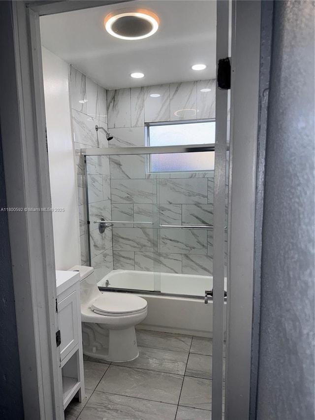 bathroom with marble look tile flooring, toilet, enclosed tub / shower combo, and vanity