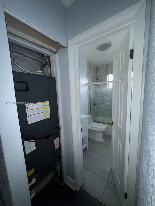full bath with toilet, vanity, and bath / shower combo with glass door