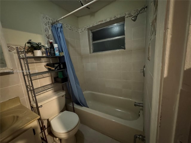 bathroom featuring tile walls, shower / bath combination with curtain, toilet, and vanity