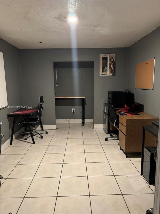 office area with a textured ceiling and light tile patterned floors