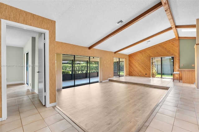 8400 NW 52nd St, Lauderhill, FL 33351 - unfurnished room with a textured ceiling, wooden walls, baseboards, and light tile patterned floors