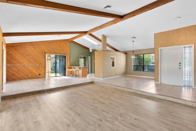 8400 NW 52nd St, Lauderhill, FL 33351 - unfurnished living room with wooden walls, wood finished floors, ceiling fan, and baseboards