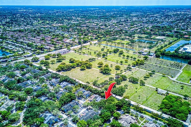aerial view of property and surrounding area featuring a large body of water and large plots for crops
