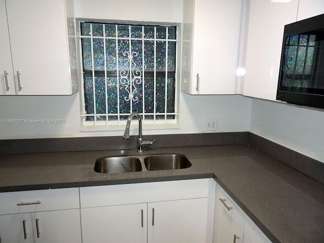 13500 NE 3rd Ct Unit 217, North Miami, FL 33161 - kitchen with dark countertops, white cabinets, and black microwave