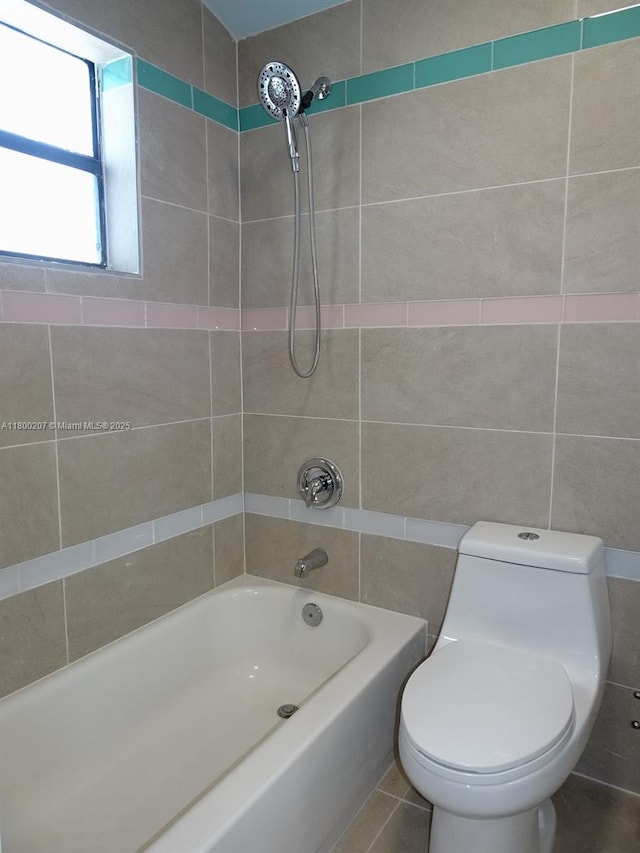 13500 NE 3rd Ct Unit 217, North Miami, FL 33161 - bathroom featuring tub / shower combination, toilet, tile walls, and tile patterned floors