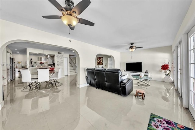1060 SW 111th Way, Davie, FL 33324 - living room featuring a ceiling fan, arched walkways, stairway, and light tile patterned flooring