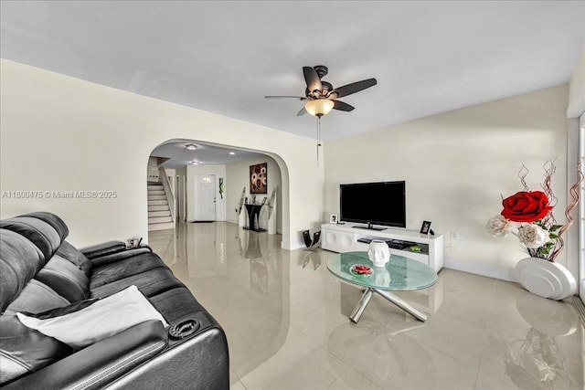 1060 SW 111th Way, Davie, FL 33324 - tiled living room with arched walkways, ceiling fan, baseboards, and stairway
