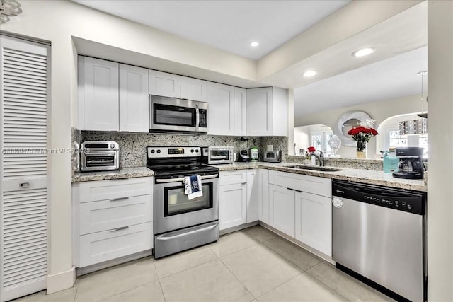 1060 SW 111th Way, Davie, FL 33324 - kitchen with stainless steel appliances, a sink, white cabinets, tasteful backsplash, and recessed lighting