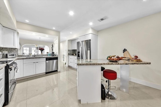 1060 SW 111th Way, Davie, FL 33324 - kitchen with appliances with stainless steel finishes, light stone countertops, tasteful backsplash, a sink, and recessed lighting