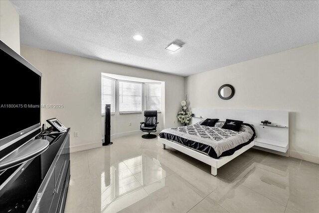 1060 SW 111th Way, Davie, FL 33324 - bedroom with a textured ceiling, tile patterned flooring, and baseboards