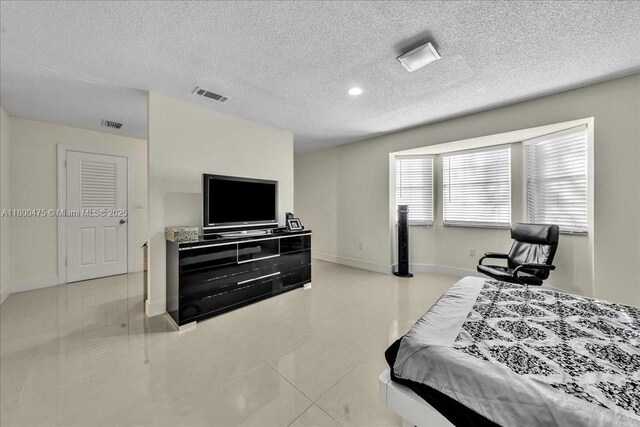 1060 SW 111th Way, Davie, FL 33324 - tiled bedroom with a textured ceiling and baseboards