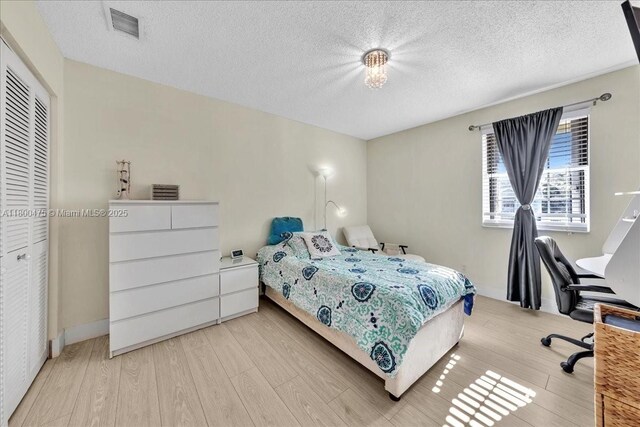 1060 SW 111th Way, Davie, FL 33324 - bedroom with light wood-style flooring, a textured ceiling, and a closet
