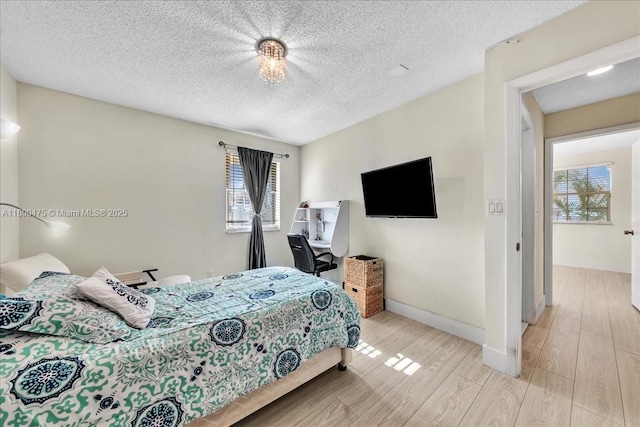 1060 SW 111th Way, Davie, FL 33324 - bedroom featuring multiple windows, light wood-type flooring, a textured ceiling, and baseboards
