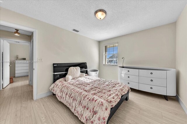 1060 SW 111th Way, Davie, FL 33324 - bedroom featuring wood finished floors, a textured ceiling, and baseboards