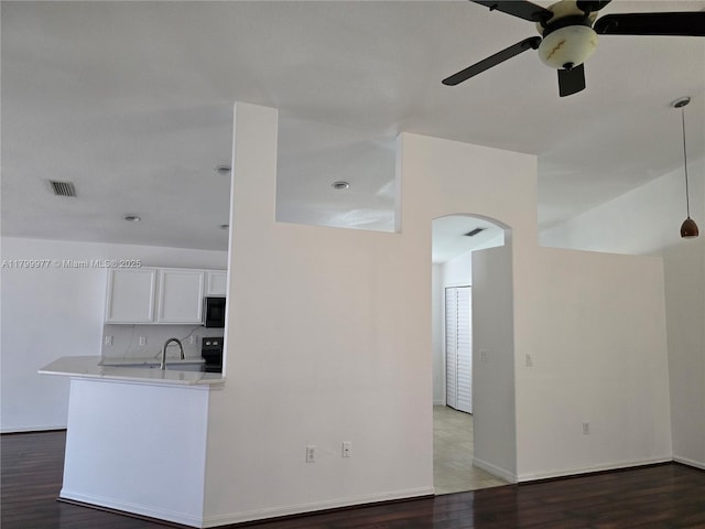 453 Dahoon Holly Dr, Daytona Beach, FL 32117 - kitchen featuring ceiling fan, arched walkways, wood finished floors, white cabinetry, and light countertops