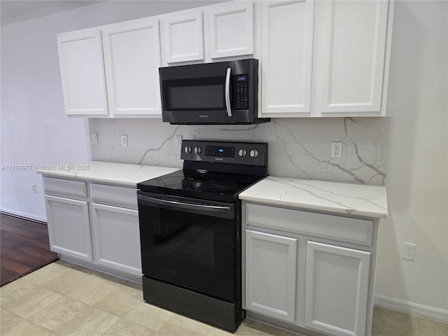 453 Dahoon Holly Dr, Daytona Beach, FL 32117 - kitchen with black range with electric cooktop, tasteful backsplash, white cabinetry, and light stone counters