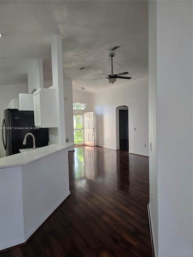 453 Dahoon Holly Dr, Daytona Beach, FL 32117 - kitchen with a ceiling fan, freestanding refrigerator, dark wood-style flooring, light countertops, and white cabinets