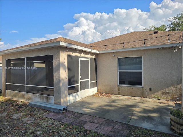 453 Dahoon Holly Dr, Daytona Beach, FL 32117 - view of home's exterior with a sunroom, stucco siding, a patio area, and roof with shingles