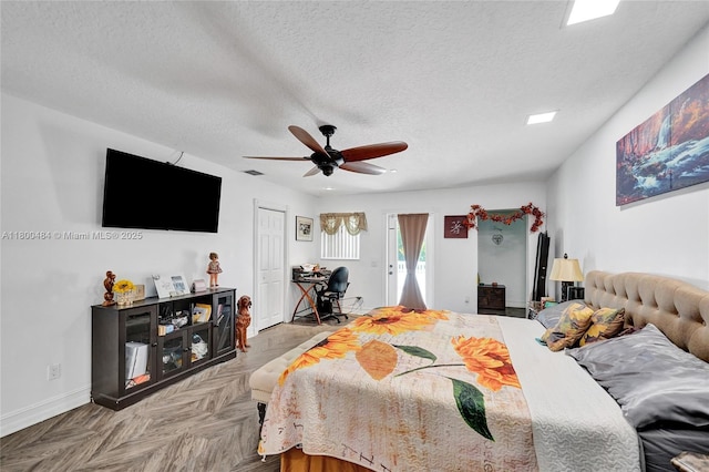 bedroom with a textured ceiling, baseboards, a desk, and a ceiling fan