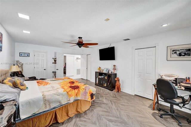 bedroom with two closets, an office area, baseboards, and ceiling fan