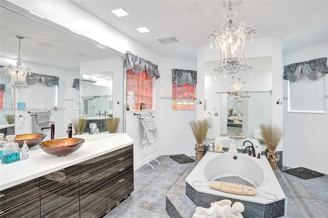 full bath featuring a chandelier, a bath, and vanity