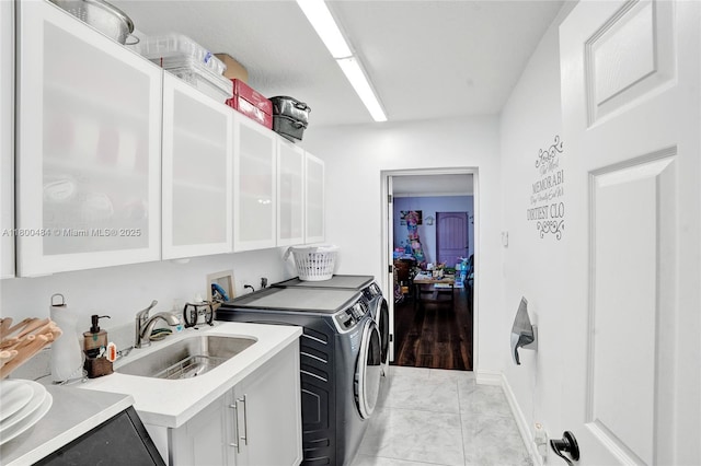 clothes washing area with washer and dryer, cabinet space, and light marble finish flooring