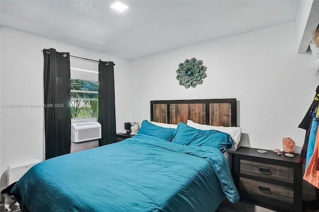 bedroom with cooling unit and wood finished floors