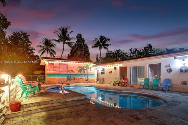 swimming pool featuring a patio and an in-ground hot tub