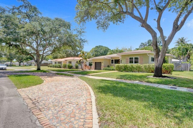 825 NE 98th St, Miami Shores, FL 33138 - ranch-style house with curved driveway, a garage, and stucco siding