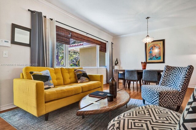 825 NE 98th St, Miami Shores, FL 33138 - living area with wood finished floors, crown molding, baseboards, and a chandelier