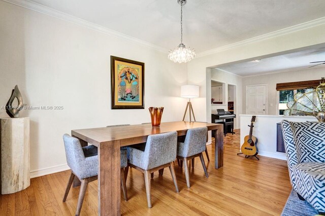 825 NE 98th St, Miami Shores, FL 33138 - dining space featuring light wood-style floors, a chandelier, ornamental molding, and baseboards