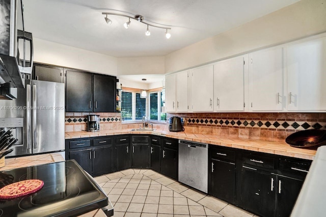 825 NE 98th St, Miami Shores, FL 33138 - kitchen with appliances with stainless steel finishes, dark cabinetry, a sink, and white cabinetry