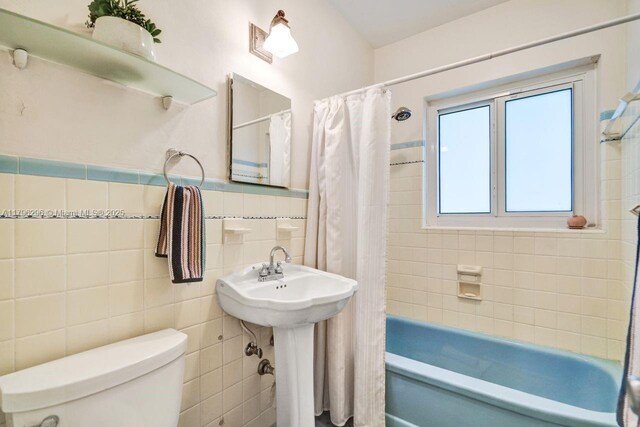 825 NE 98th St, Miami Shores, FL 33138 - full bath with tile walls, toilet, shower / bath combo, and a wainscoted wall