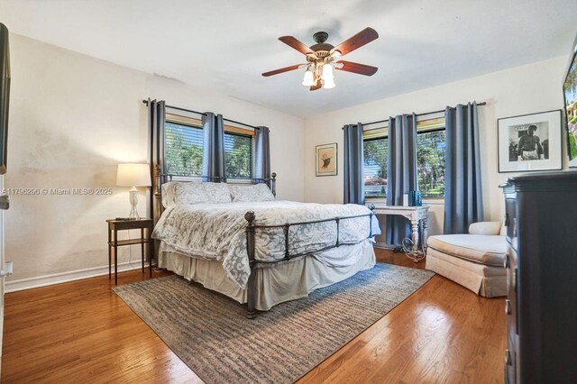 825 NE 98th St, Miami Shores, FL 33138 - bedroom featuring multiple windows, wood finished floors, baseboards, and ceiling fan